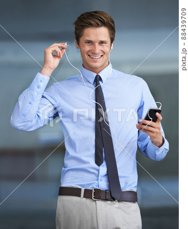 Music gets me into the working mood. Portrait of a handsome young businessman using his smartphone as an mp3 player. 88439709