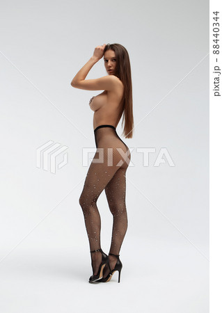 Sexy woman in tights and high heeled shoes in studio 88440344