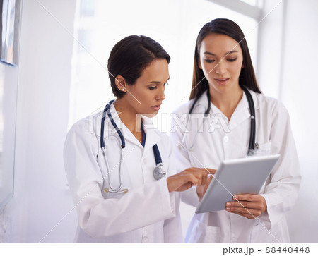 Its easier if you go in this way. Shot of a young doctor getting advice from a colleague. Its easier if you go in this way. Shot of a young doctor getting advice from a colleague. 88440448