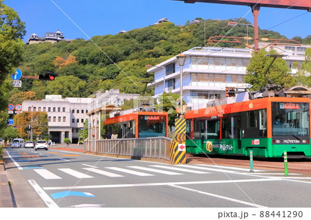 【愛媛県】松山市役所前から見た秋の松山城と伊予鉄電車 88441290