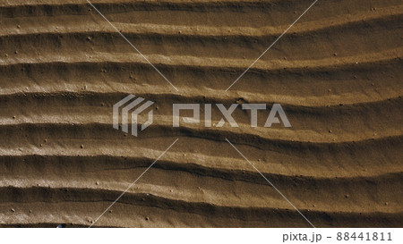 Stripes of fine sea sand on the coast. Natural background from the sand of the sea. 88441811