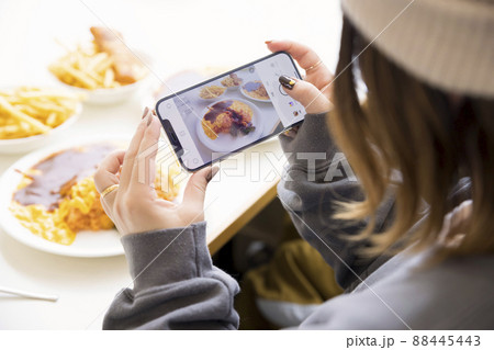 レストランで料理の写真を携帯で撮影する女性手元 88445443