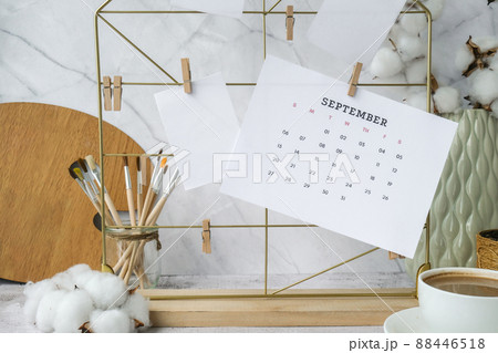 SEPTEMBER CALENDAR cards and posters mock ups on grid board. Copy space. Home office desktop. Freelance bloggers workplace. Brushes and palette 88446518
