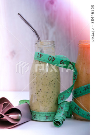 Seasonal Matcha green vegan smoothie and pumpkin carrot smoothie drink detox Breakfast with measuring tape and rubber resistance band. Stretch fitness band. Clean eating, weight loss, healthy dieting Seasonal Matcha green vegan smoothie and pumpkin carrot smoothie drink detox Breakfast with measuring tape and rubber resistance band. Stretch fitness band. Clean eating, weight loss, healthy dieting 88446559