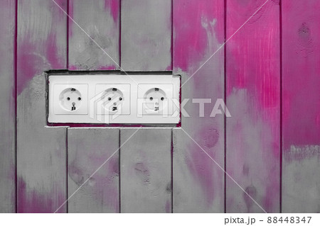 White triple power socket electric outlet plug voltage on wooden painted decorative color boards modern interior 88448347
