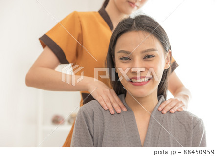 In a spa salon, a young woman enjoys massage therapy. In a spa salon, a young woman enjoys massage therapy. 88450959