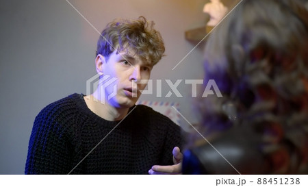 A young couple meets in a nightclub bar. A guy swears with a girl. The couple drinks alcohol. Night club A young couple meets in a nightclub bar. A guy swears with a girl. The couple drinks alcohol. Night club 88451238