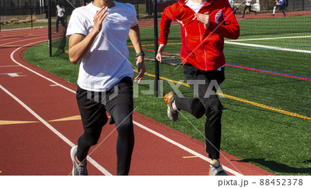 Boys running fast on a track two by two 88452378