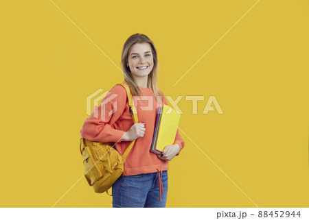 Happy university student with backpack and notebooks isolated on color background Happy university student with backpack and notebooks isolated on color background 88452944