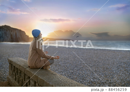 A woman doing yoga at the beach, at sunset time A woman doing yoga at the beach, at sunset time 88456259