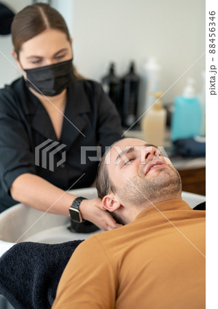 Female hairdresser washing hair to the customer 88456346