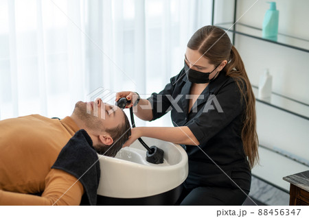 Female hairdresser washing hair to the customer 88456347