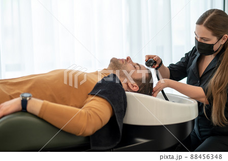 Female hairdresser washing hair to the customer 88456348