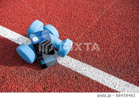 Gym app. Smartphone screen with sport gym or fitness health mobile application on dumbbell background. App for training indoors.  88456462