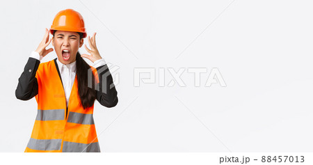Mad and outraged asian female chief engineer, construction manager burst in rage, losing temper at employees, shouting and shaking hands aggressive, scream furious as scolding someone 88457013