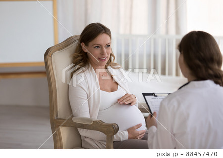 Gynecologist doctor meeting with pregnant patient, asking questions 88457470