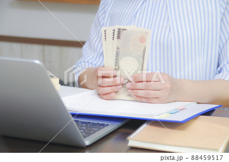 パソコンの前でお金を持つ女性 パソコンの前でお金を持つ女性 88459517