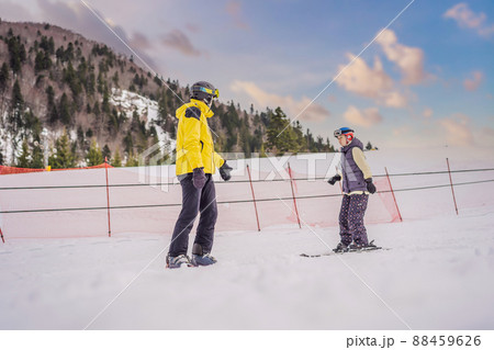 Woman learning to ski with instructor. Winter sport. Ski lesson in alpine school Woman learning to ski with instructor. Winter sport. Ski lesson in alpine school 88459626
