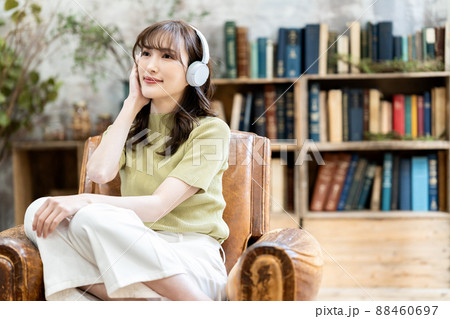 ヘッドフォンで音楽を聴く若い女性 88460697