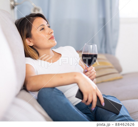 Latino woman relaxing at evening with glass of red wine 88462626