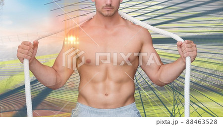 Light spot against mid section of caucasian fit man with a rope against sports field 88463528