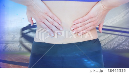 Close up of caucasian female athlete holding her injured waist over digital waves and sports field 88463536