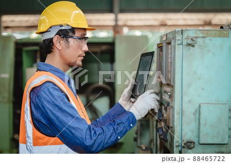 Engineer worker program setup CNC machine in metal industry factory with tablet technology. 88465722