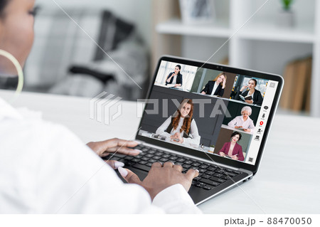 Online conference. Virtual meeting. Remote cooperation. Business woman using laptop discussing project with team on screen in digital office. 88470050