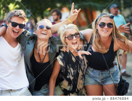 High on music and life. Four young friends rocking out to a band at a music festival. 88476884
