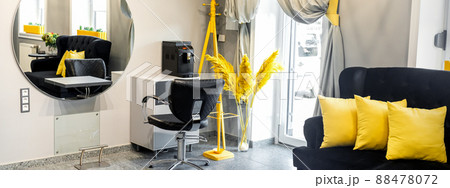 Modern small bright hair and beauty salon in black and yellow colors with gray walls and floor and black sofa with yellow cushions Modern small bright hair and beauty salon in black and yellow colors with gray walls and floor and black sofa with yellow cushions 88478072