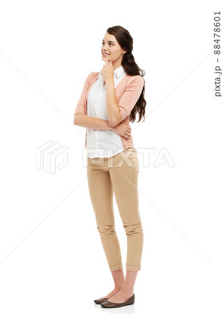 Thinking it over. Full length young woman with her hand on her chin while thinking against a white background. 88478601