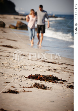 Arm-in-arm always and forever. Full length shot of a young couple walking arm in arm along a sandy beach. 88479125