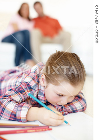 Im drawing a flower. A young girl lies on the floor and colours in. Im drawing a flower. A young girl lies on the floor and colours in. 88479435