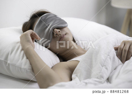 Young woman with eye mask sleeping in her bed and relaxing in the morning Young woman with eye mask sleeping in her bed and relaxing in the morning 88481268