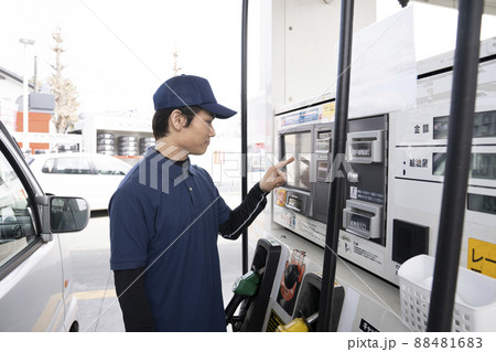 セルフのガソリンスタンドで給油する男性 88481683