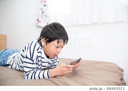 子供部屋でスマホを見ているアジア人の男の子 子供部屋でスマホを見ているアジア人の男の子 88483021