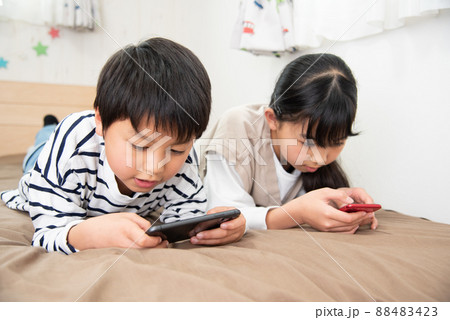 子供部屋でスマホを見ているアジア人の子供 子供部屋でスマホを見ているアジア人の子供 88483423