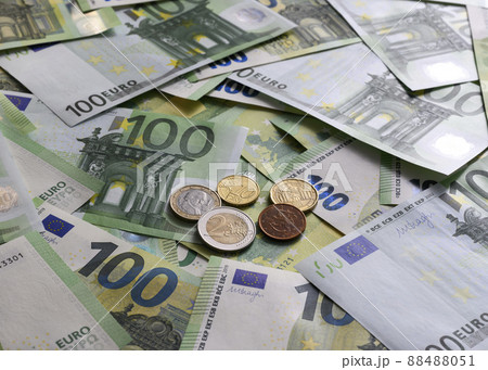 Euro cent coins on the background of 100 Euro banknotes arranged in random order Euro cent coins on the background of 100 Euro banknotes arranged in random order 88488051