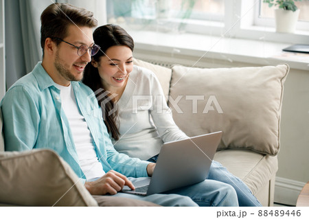 Young couple enjoy Social teleconferencing with their family via laptop screen in condominium social distancing 88489446