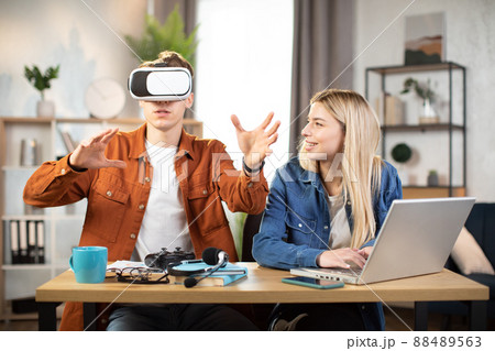 Excited young people using VR glasses for having fun at home Excited young people using VR glasses for having fun at home 88489563