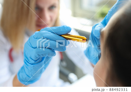 Doctor ophthalmologist shines light in patient eyes 88492331