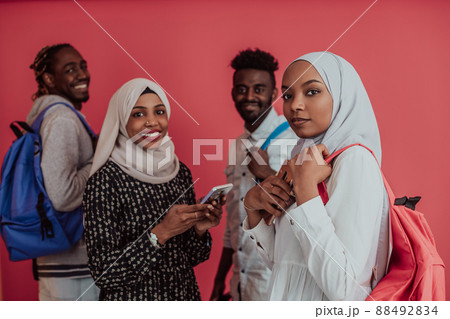 A group of African Muslim students with backpacks posing on a pink background. the concept of school education. 88492834