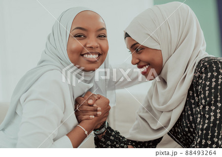 African woman arm wrestling conflict concept, disagreement and confrontation wearing traditional islamic hijab clothes. Selective focus African woman arm wrestling conflict concept, disagreement and confrontation wearing traditional islamic hijab clothes. Selective focus 88493264