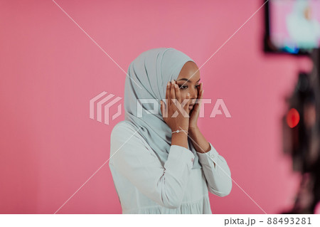 Modern African Muslim woman makes traditional prayer to God, keeps hands in praying gesture, wears traditional white clothes, has serious facial expression, isolated over plastic pink background Modern African Muslim woman makes traditional prayer to God, keeps hands in praying gesture, wears traditional white clothes, has serious facial expression, isolated over plastic pink background 88493281
