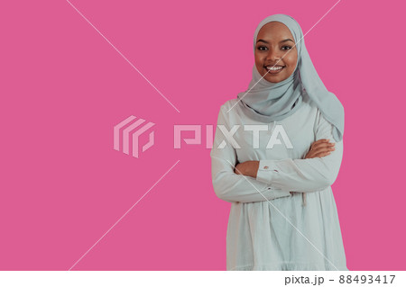 Portrait of young modern muslim afro beauty wearing traditional islamic clothes on plastic pink background. Selective focus  88493417