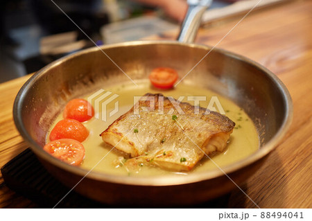 Dish of fish fillet with salad on dripping pan close up. Dish of fish fillet with salad on dripping pan close up. 88494041