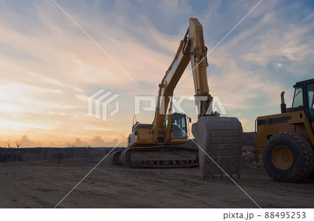 construction heavy hydraulics equipment excavator shovel yellow machine earth movers sunset clouds 88495253
