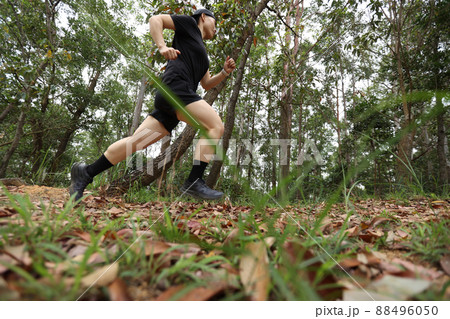 Woman runner running on forest trail Woman runner running on forest trail 88496050