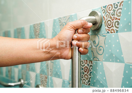 Asian woman patient use toilet support rail in bathroom, handrail safety grab bar, security in nursing hospital. Asian woman patient use toilet support rail in bathroom, handrail safety grab bar, security in nursing hospital. 88496834