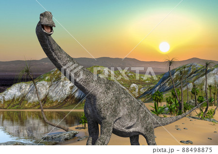 水と植物が豊かな大地に太陽が昇る情景を背景に一匹のプラキオサウルスが口を開けて水辺を歩いている 88498875